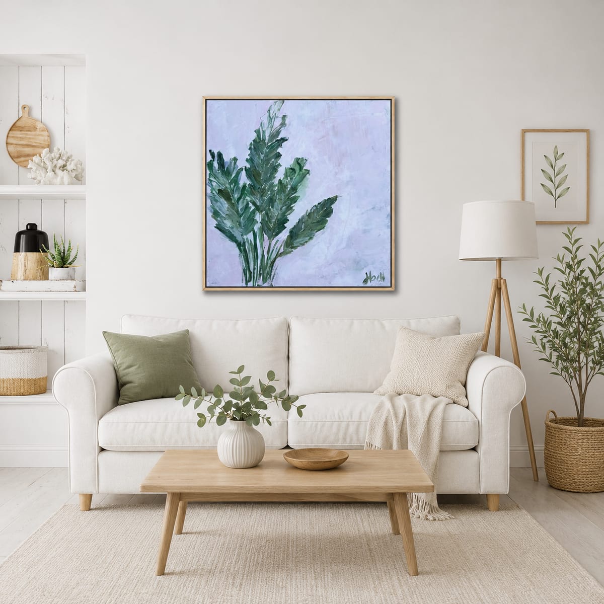 Botanical painting of green leaves by Jen Bell above a white sofa.