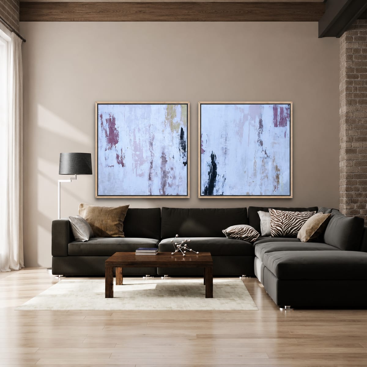 Two abstract paintings in mauve and white by Jen Bell above a charcoal sofa.