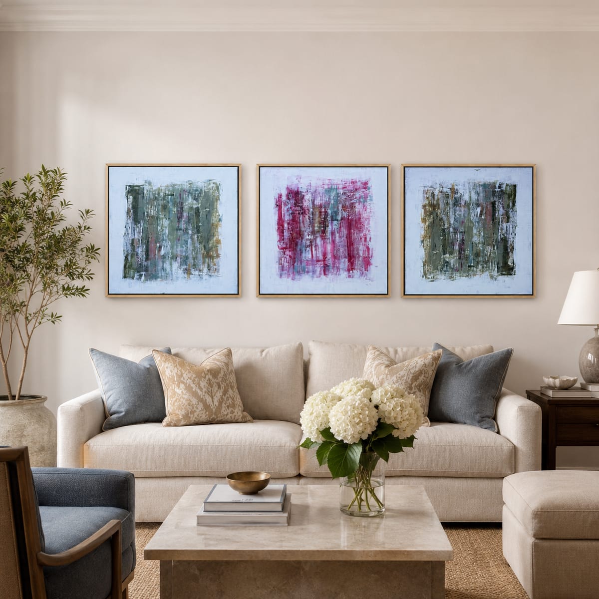 Triptych of green and pink abstract paintings by Jen Bell above a cream sofa.